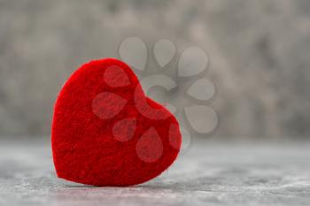 Heart symbol made from red felt on a stone background