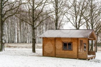 Vacation rural winter background with small wooden house covered with snow