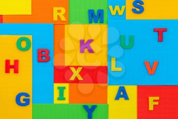 Plastic letters on the vibrant colorful paper background