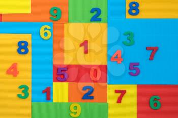 Plastic numbers on the vibrant colorful paper background