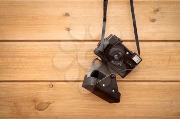 Old 35mm camera hanging on wood wall. Copy-space.