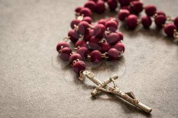 Catholic rosary lying on the stone background