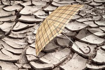 Umbrella on the arid soil from the heat. Concept of global warming