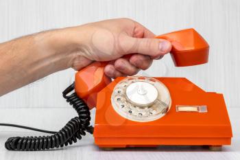 Human hand picking up the phone. Customer service or communication concept