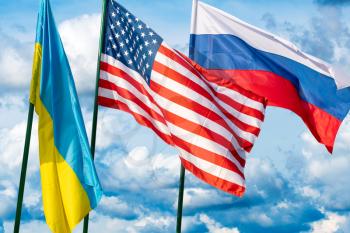 Ukraine, USA and Russia flags. Waving flags on the cloudy sky background.  Ukraine Russia relations, sanctions and Crimea conflict war concept with USA support or mediation