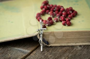 Catholic rosary lie on the opened ancient book
