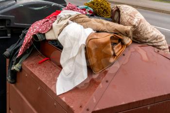 Full container of disposal clothes. Old clothes collection container on the street