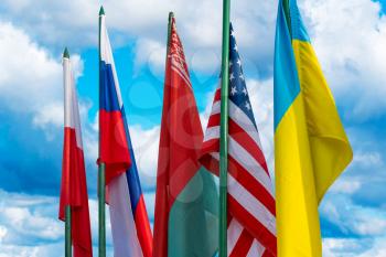Ukraine, USA, Belarus, Russia and Poland flags. Flags in a one row on the cloudy sky background. 