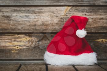 Christmas time - Santa hat on the wheatered wood background