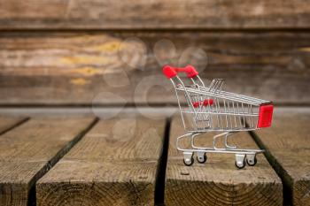 Small shopping cart on wheatered wood background