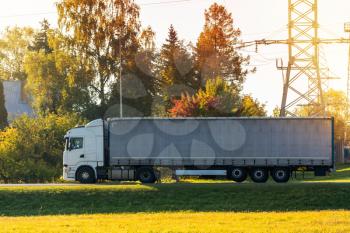 Truck transports goods by road - shipping and logistics.Truck with container on highway, cargo transportation concept.