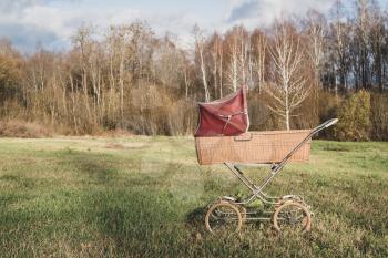 Retro style stroller baby carriage outdoors during autumn season