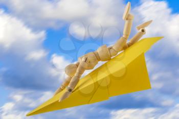 Wooden doll with paper aircraft landing very fast. Conceptual image.