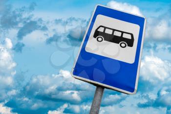 Bus stop sign in a front of cloudy sky
