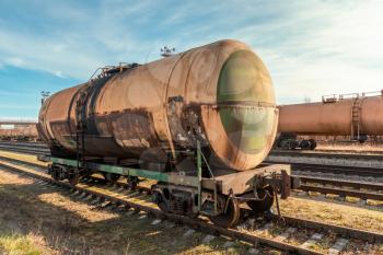 Grunge petroleum waggon on the railroad. Train delivering oil or gas.