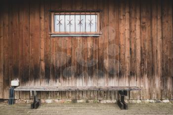 Wooden bench against wooden wall with small window