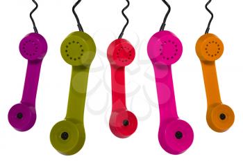 Different colors phone receivers hanging on white background