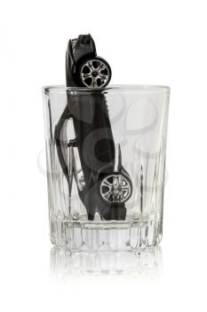 Toy car in a vodka glass isolated on white background. The concept of Drunk driving