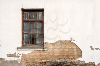 Window in damaged wall of an abandoned house
