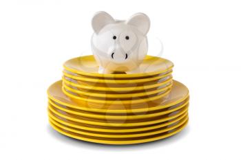 Savings consumer concept. Piggy bank on the stack of dinner plates