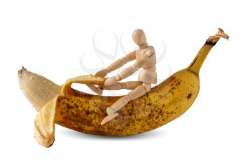 Wooden doll peeling a banana, isolated on white background