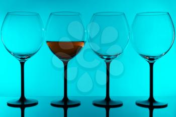 Four Wineglass on blue background with reflection