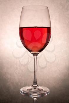 Wineglass with red wine on vintage background