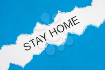 Stay at home concept. Torn paper with words STAY HOME  on a white background. Coronavirus, COVID-19, self-quarantine, isolation