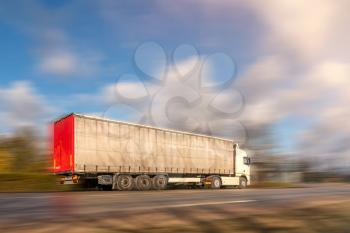 Truck on asphalt road motion blur. Truck with container on highway, cargo transportation concept.
