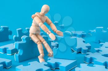 Wooden man assembling jigsaw puzzle. Concept for consulting, marketing, business, strategy and planning.