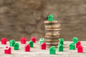 Mini houses and stack of coins. Concept of Investment property.