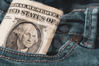 One American dollar sticking out of the blue jeans pocket