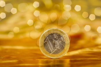 European currency. Euro Coin on a gold background with nice bokeh. A standing coin. Cash money.