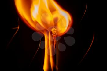 Ignition of a match, with smoke on dark background. A beauty of burning match, isolated in black background. Fire styling.