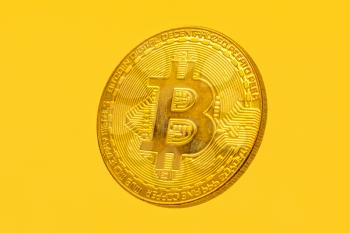Shiny Gold Bitcoin coin flying on a yellow background