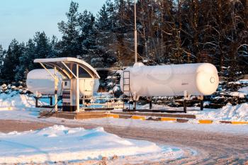Fuel tank of liquid propane gas station. Fuel tank of LPG station under snow. Winter view of LPG station for filling liquefied gas into the vehicle. Environmentally friendly fuel.