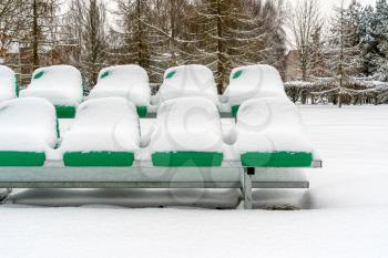 Seats of stadium after a strong snowfall. Stadium for game in football(soccer).