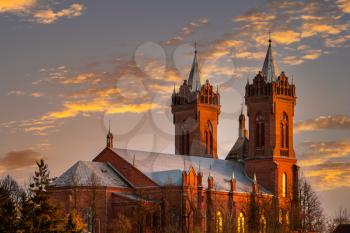 Scenic view of roofs of a tall church with bell towers on the sunset 
