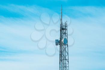 Telecommunication tower with  antennas and satellite dish on clear blue sky