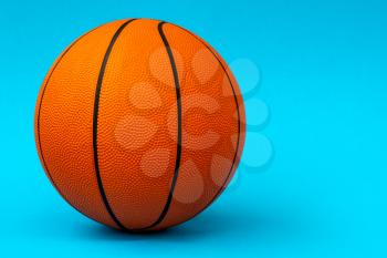 Orange basketball ball isolated on blue background. Copy space.
