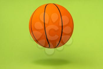 Orange basketball ball isolated on green background