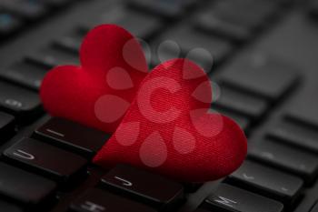 Small red hearts on computer keyboard. Internet dating concept. 