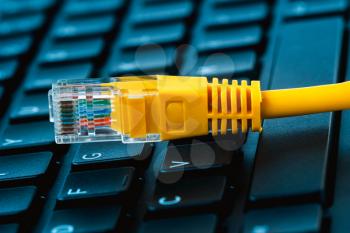Network access technology concept. Internet lan cable on a desktop keyboard.Online forbidden resource conceptual.