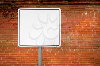 Blank signpost against the brick wall. Empty rectangular frame for text, images and ads. 
