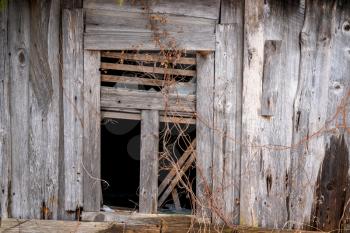 Old abandoned weathered wooden house with broken window