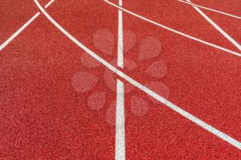 Newly made running track with rubber cover. Visible surface texture, freshly painted lines.
