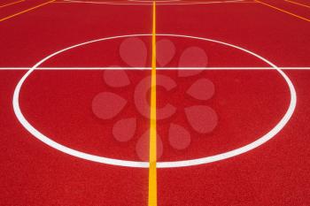 Center of newly made outdoor basketball court in park. Visible surface texture, freshly painted lines.