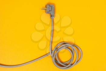 Electric cable with plug on a yellow background. Copy space.