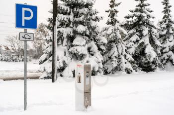 Modern electric car charging station after heavy snowfall