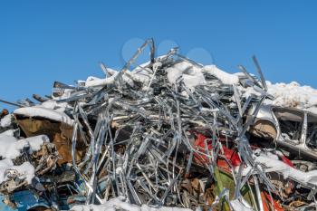 Pile of scrap metal under blue sky during winter season